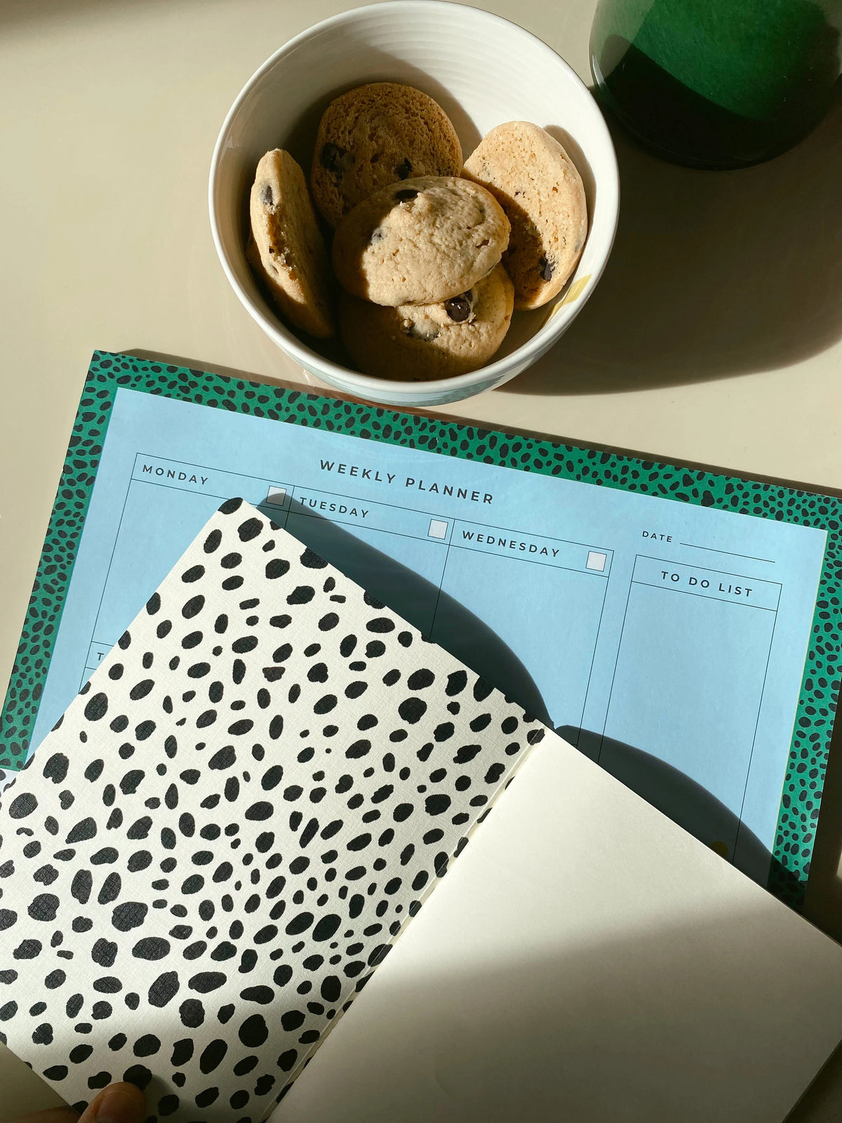 Open Dalmatian notebook showing spotted endpapers and a blank ivory page beside a matching planner.