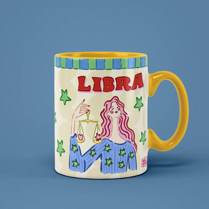 Libra zodiac mug with a pink-haired figure holding golden balance scales