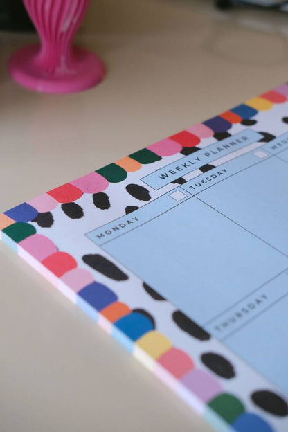 Close-up of the Rainbow weekly planner showing the writing layout and colourful spotted border.